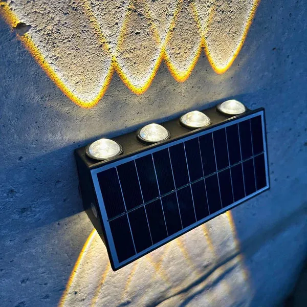Aplique solar de 8 luces encendido sobre una pared de noche